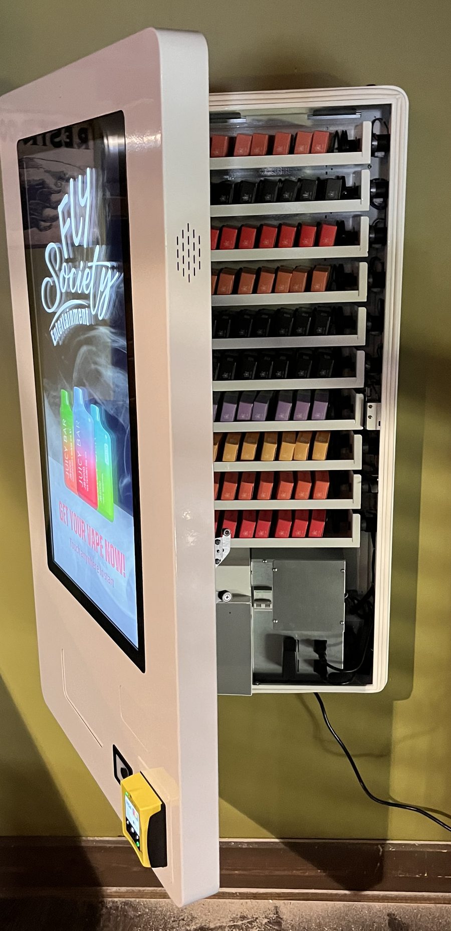 Vending machine with its door open, showing rows of stocked disposable vapes